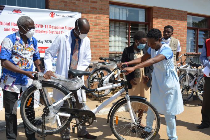 Official from Mbelwa council handing a bicyle to the beneficiary