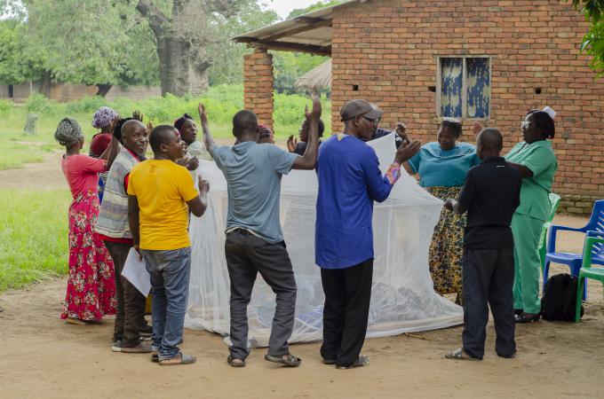 CHAGs and Community Nurses demonstrate how to use a Mosquito net