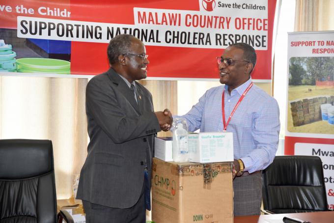 Save the Children Country Director, Ashebir Debebe (Right) makes a symbolic handover of the medical supplies to Secretary for Health Dr. Charles Mwansambo at Ministry of Health Offices in Malawi’s Capital City Lilongwe. Picture Credits – Thokozile Makawa/Save the Children